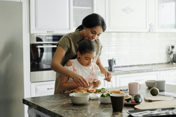 Madre cocinando con su hija de forma relajada. Movimiento slow. slow food