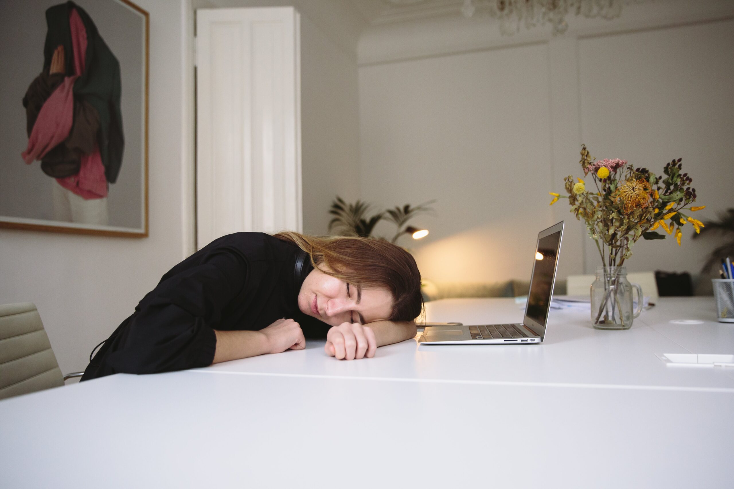 La importancia de planificar el descanso en la semana.Mujer se duerme trabajando encima de la mesa.